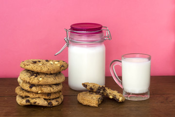 homemade white and black chocolate cookies on wood table with milk