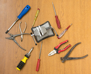 small portable vice screwdriver tools for repair  randomly scattered on the work surface