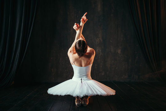 Female classical ballet performer sitting on floor