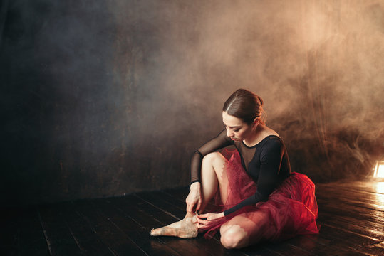 Ballet dancer tying pointe shoes