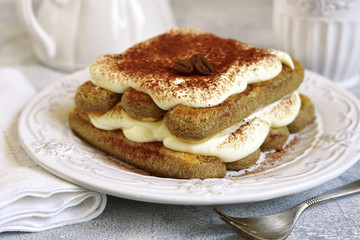 Portion of tiramisu cake on a white vintage plate.