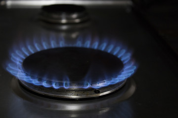 Gas cooker and blue flames in a kitchen with black shadows