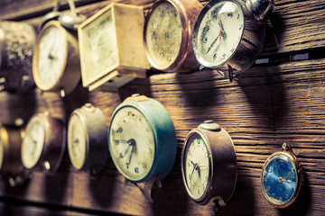 Mix of old clocks on the wooden wall
