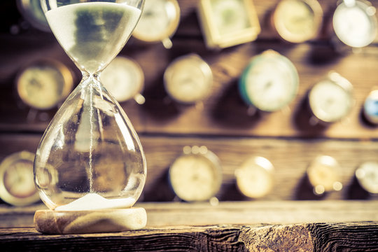 Closeup of old hourglass on clocks background
