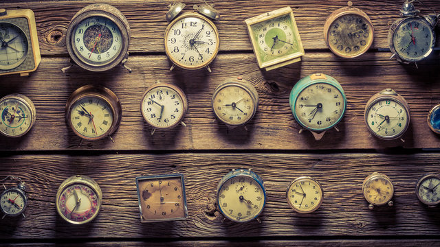 Mix of aged clocks on the wooden wall - Powered by Adobe
