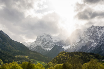 Die Sonne scheint durch die Wolken in den Alpen