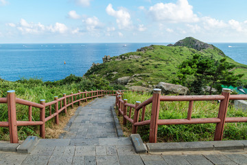 Fototapeta premium Dragons head reaching into the ocean with path at Yongmeori Beach, Sanbang-ro, Jeju Island, South Korea