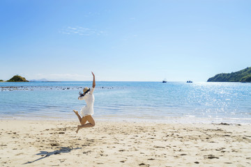 Fototapeta na wymiar Young woman jumping on the tropical beach