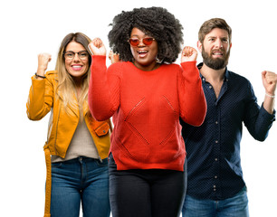 Group of three young men and women happy and excited expressing winning gesture. Successful and celebrating victory, triumphant