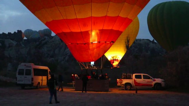 Heating a Red and Yellow Hot Air Balloon in Cappadocia
