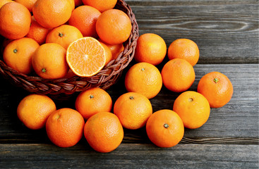 A lot of fresh Mandarin orange in basket with wooden background