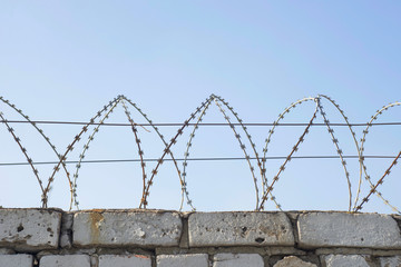 Barbed wire wound to the top of a brick fence