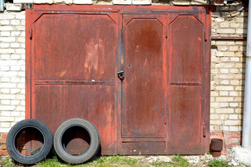 Rusty garage doors with remnants of red paint.