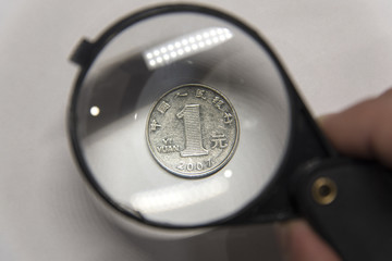 One yuan under magnifying glass