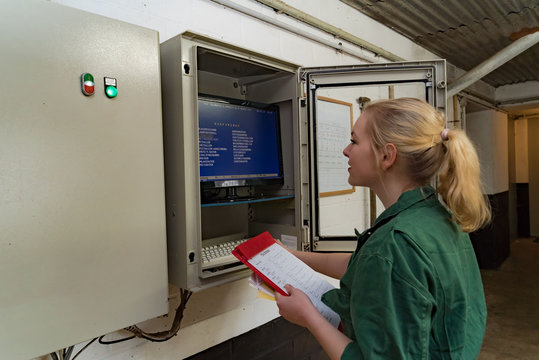 Mechanisierung &iacute;n der Schweinehaltung, junge Landwirtin kontrolliert die EDV