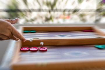 Playing backgammon on a wooden board with dices