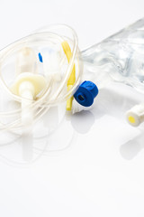 IV drip chamber, tubing, and bag of solution on a white table in a hospital.