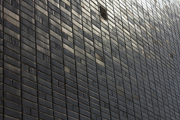 black tiles wall with sun reflection