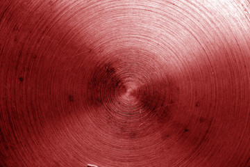 Metal surface with scratches in red tone.