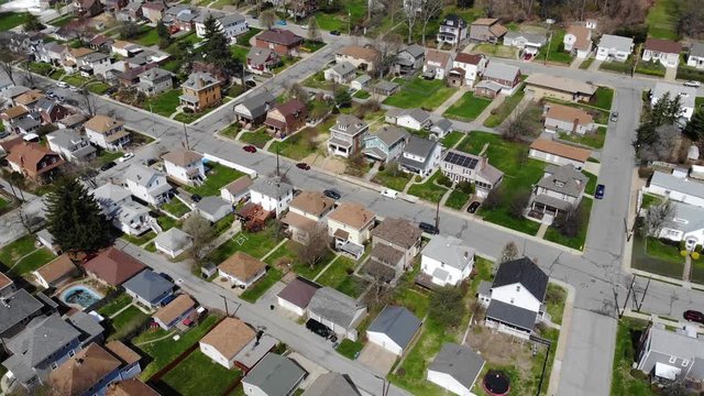 A daytime late winter slow forward aerial establishing shot of a typical residential neighborhood in a Western Pennsylvania small town. Pittsburgh suburbs.  	
