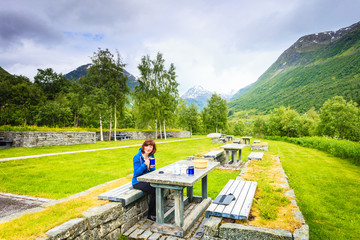 Traveler woman have lunch on nature in norwegian mountains