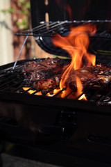Lamb chops with mint marinade cooking on a barbecue with flames