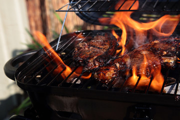 Lamb chops with mint marinade cooking on a barbecue with flames
