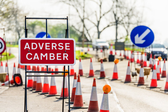 Adverse Camber Roadworks sign on UK motorway with cones
