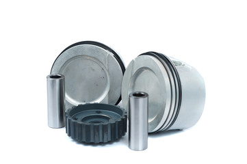 Close-up of spare parts two new pistons with connecting rods for a gasoline engine with installed sets of piston rings and crankshaft sprocket on an isolated white background