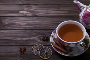 Teapot tea cup on brown wooden table.