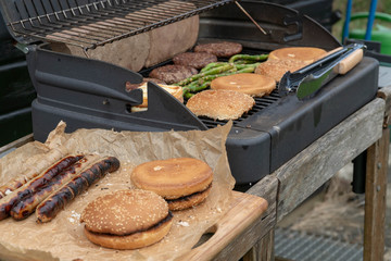 Hamburger Set. The person is going to grill beef patties, sausages, grilled cheese and asparagus