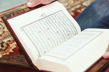 Naklejka na ściany i meble Muslim man reading Islamic holy book quran