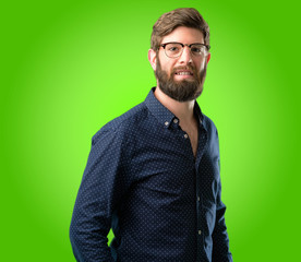 Fototapeta premium Young hipster man with big beard confident and happy with a big natural smile laughing over green background