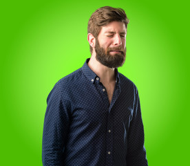 Young hipster man with big beard with sad and upset expression, unhappy over green background