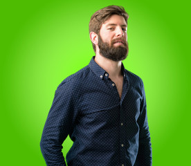 Young hipster man with big beard confident and happy with a big natural smile looking at camera over green background