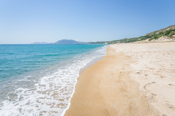 Beautiful sunny coast view to the greek mediterranean blue sea with crystal clear water and pure sandy beach empty place with some mountains rocks surrounded, Kefalos, Kos Island, Dodecanese, Greece