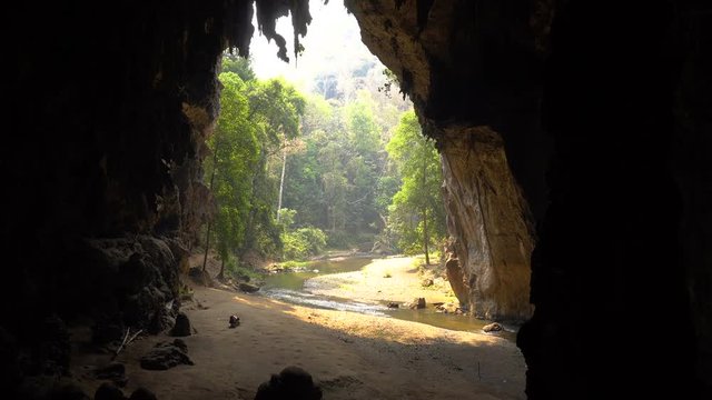 Older Woman is Collecting Bat Guano on the Bottom of Big Cave with River Flowing from the Bowels. Lod Cave Thailand, Pai.