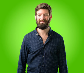 Fototapeta premium Young hipster man with big beard confident and happy with a big natural smile laughing over green background