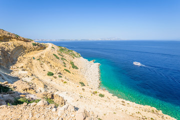 Beautiful sunny coast view to the greek mediterranean blue sea after a long hiking day resting at an empty place with some mountains rocks surrounded, Kefalos, Kos, Dodecanese Islands, Greece