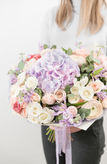 lilac and light bouquet of beautiful flowers in women's hands. Floristry concept. Spring colors. the work of the florist at a flower shop. Vertical photo
