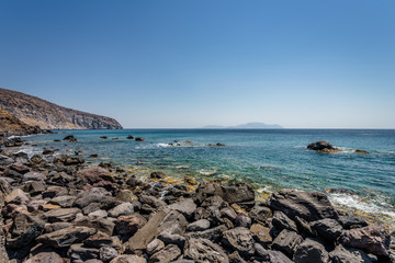 Sunny beautiful summer coast view to the greek blue sea with shallow clear water and small volcano rocks at empty shore escape relax swim, Avlaki Beach, Nisyros Island, Kos, Dodecanese, Greece