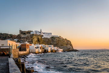 Beautiful sunset sunrise coast view to old ancient monastery church on a cliff of mediterranean greek village Mandraki, Monastery of Panagia Spiliani, Nisyros Island, Kos, Dodecanese, Greece 