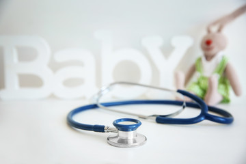 Conceptual photo of stethoscope and blurred word BABY on background