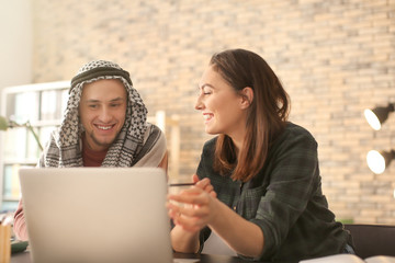 Female student with her Muslim classmate in library