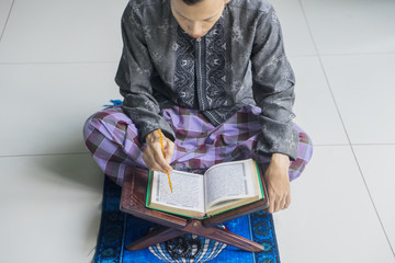 Fototapeta na wymiar Devout young muslim man reading Koran