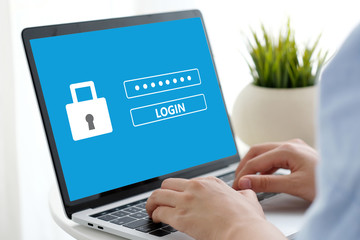 Hand tying laptop computer with password login on screen, cyber security concept