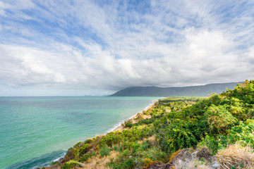 Cloudy stormy warm summer day with view to blue wild wave sea coast with sandy white beaches perfect for surfing swimming or walking under palm trees, Palm Cove, Cairns, Daintree Queensland, Australia