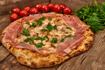Homemade fresh delicious gourmet pizza whit shrimps, porcini mushrooms, speck, garlic and fresh parsley,Tasty italian pizza isolated on wooden table,Close up with selective focus