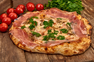 Homemade fresh delicious gourmet pizza whit shrimps, porcini mushrooms, speck, garlic and fresh parsley,Tasty italian pizza isolated on wooden table,Close up with selective focus