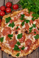 Homemade fresh delicious gourmet pizza whit salmon, garlic and fresh parsley,Tasty italian pizza isolated on wooden table,Close up with selective focus